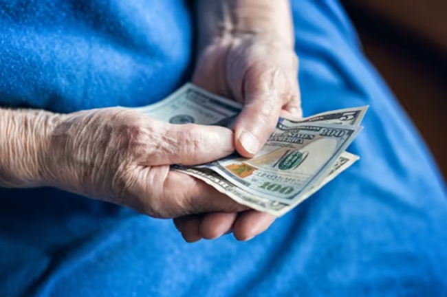 Manos de anciana contando dinero