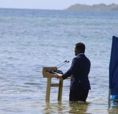 En su discurso en Conferencia de las Naciones Unidas sobre el Cambio Climático (COP26) en Glasgow, Simon Kofe, ministro de Relaciones Exteriores de Tuvalu, una nación isleña del Pacífico, vestido de traje y frente a un atril, se sumergió en el mar para demostrar cómo el aumento del nivel de los océanos y la acelerada crisis climática amenazan a su país.