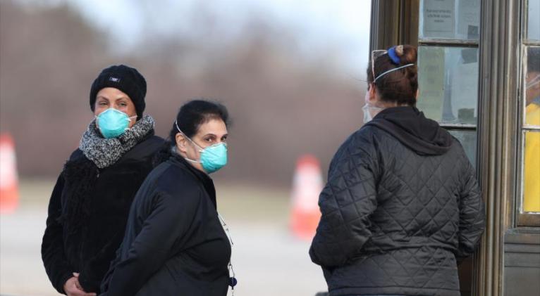 Los trabajadores observan primer punto de control de un sitio de prueba de detección de coronavirus, en Nueva York, 17 de marzo de 2020. Foto: AFP