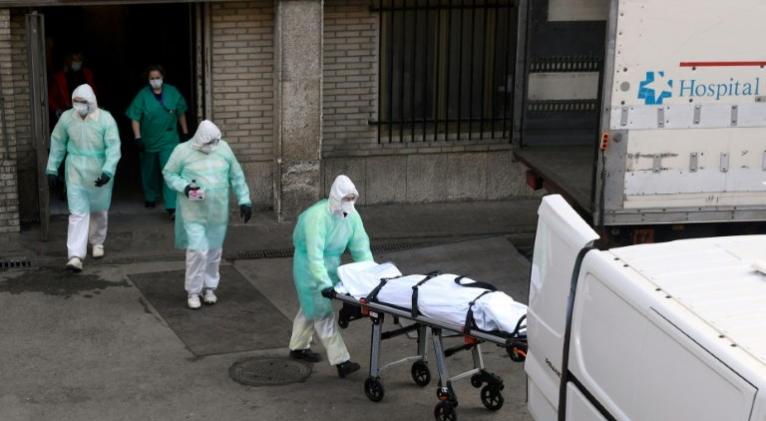 Un sanitario con indumentaria protectora saca en camilla un cadáver del hospital Gregorio Marañón de Madrid, el 25 de marzo de 2020 en la capital española© AFP Óscar del Pozo