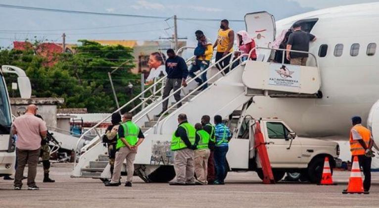 Migrantes haitianos deportados desde EE.UU. se bajan de un avión en el aeropuerto de Puerto Príncipe. Foto: EFE