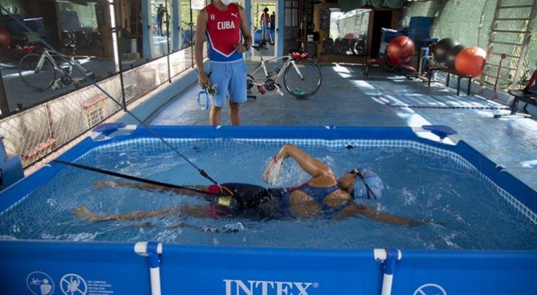 Leslie y Dióseles (al fondo), se las ingeniaron para montar un circuito de entrenamiento de las tres disciplinas que componen el triatlón en casa durante los meses de confinamiento. Foto: Ismael Francisco.