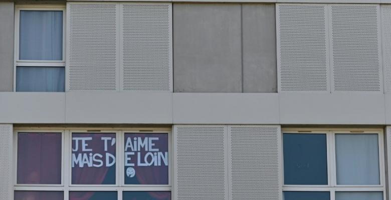 La frase ‘Te quiero, pero de lejos’ aparece en la ventana de un apartamento de la ciudad de Rennes, al noroeste de Francia, el 24 de marzo de 2020, octavo día de confinamiento en ese país por la pandemia del coronavirus© AFP/Archivos Damien Meyer