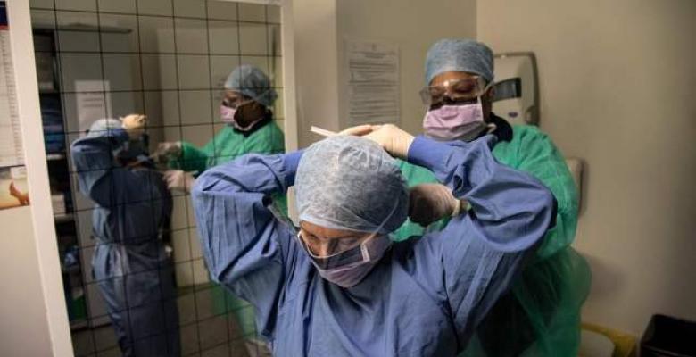 Una enfermera ayuda a una compañera a colocarse el traje protector y una máscara antes de entrar a una zona con enfermos de coronavirus, en el hospital Maria Pia de Turín, Italia. Foto Afp