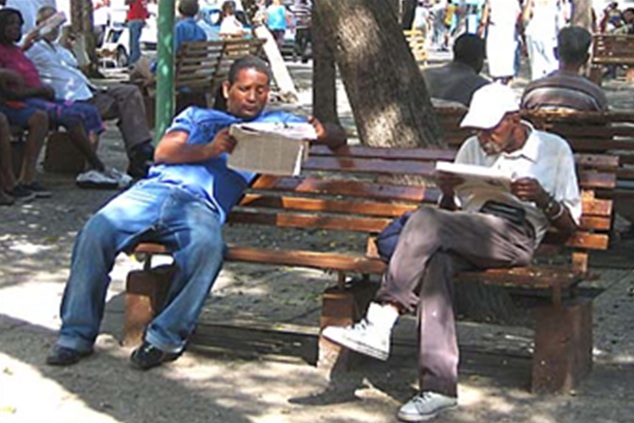Cubanos leyendo periódicos en el parque
