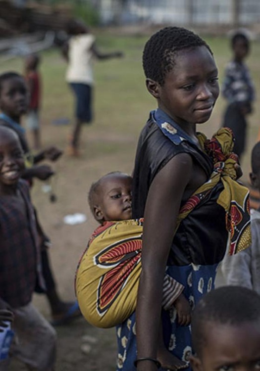 Niño africano cargando a un bebé atado a sus espaldas 