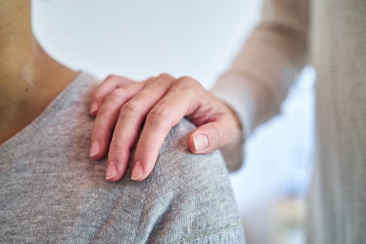 mano afectuosa sobre un hombro