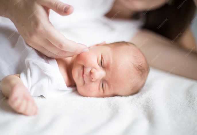 mano de mamá acariciando la cara de su bebé