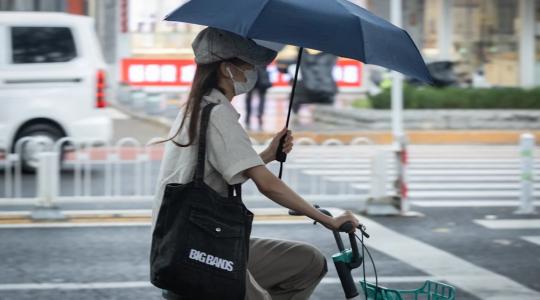 Mujer con sombrilla y bicicleta